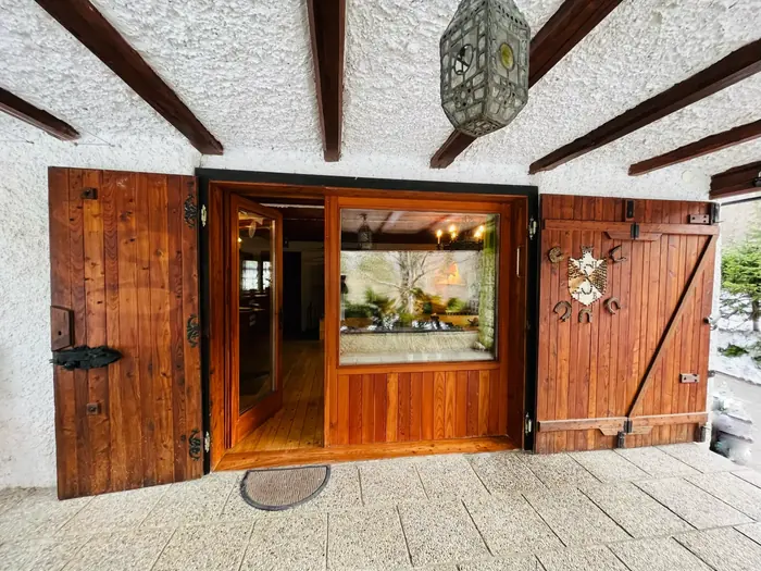The cabin's open wooden entrance doors with an antique lantern overhead
